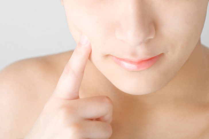 頬を触る女性